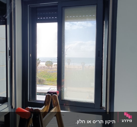 חלון עם תריסים וסולם עץ בחדר פנימי